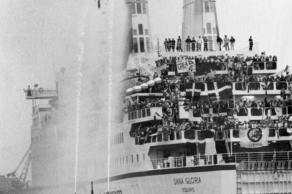 Svørthvít savnsmynd av Dana Gloria við donskum fløggum og nógvum fjepparum umborð.